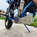 Aluminium bash plate protecting the underside of a blue off-road motorcycle