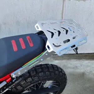 Silver Maxi carry rack fitted above off-road motorcycle rear wheel